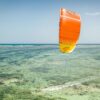 Cabrinha Moto 2021 Kite action image with the kite flying above the water, showing canopy shape, stability and on-water kitesurf performance