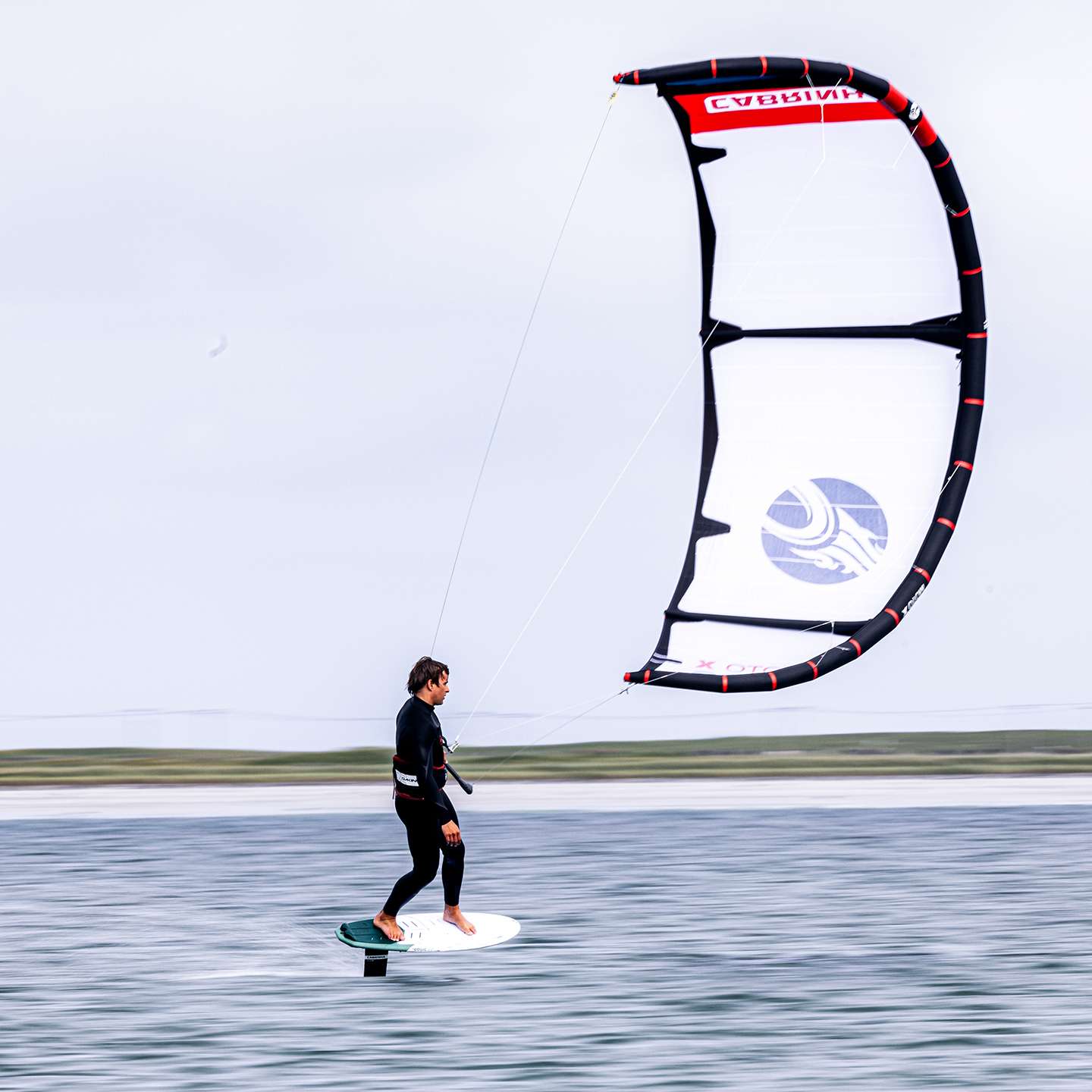 Cabrinha Moto X 2024 Kite action image with the kite flying above the water, showing canopy shape, stability and on-water kitesurf performance