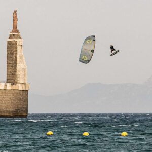 Kitesurfer boosting a Duotone Kite near a harbour wall