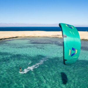 A green Duotone kite sailing in green water