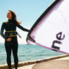 F-One Breeze TEC Kite holding kite on the beach