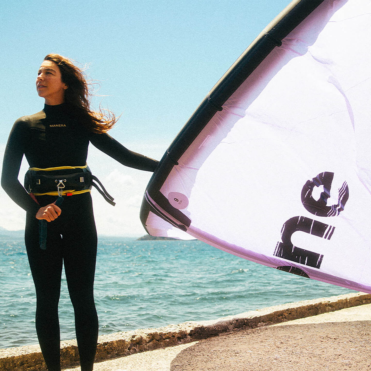 F-One Breeze TEC Kite holding kite on the beach