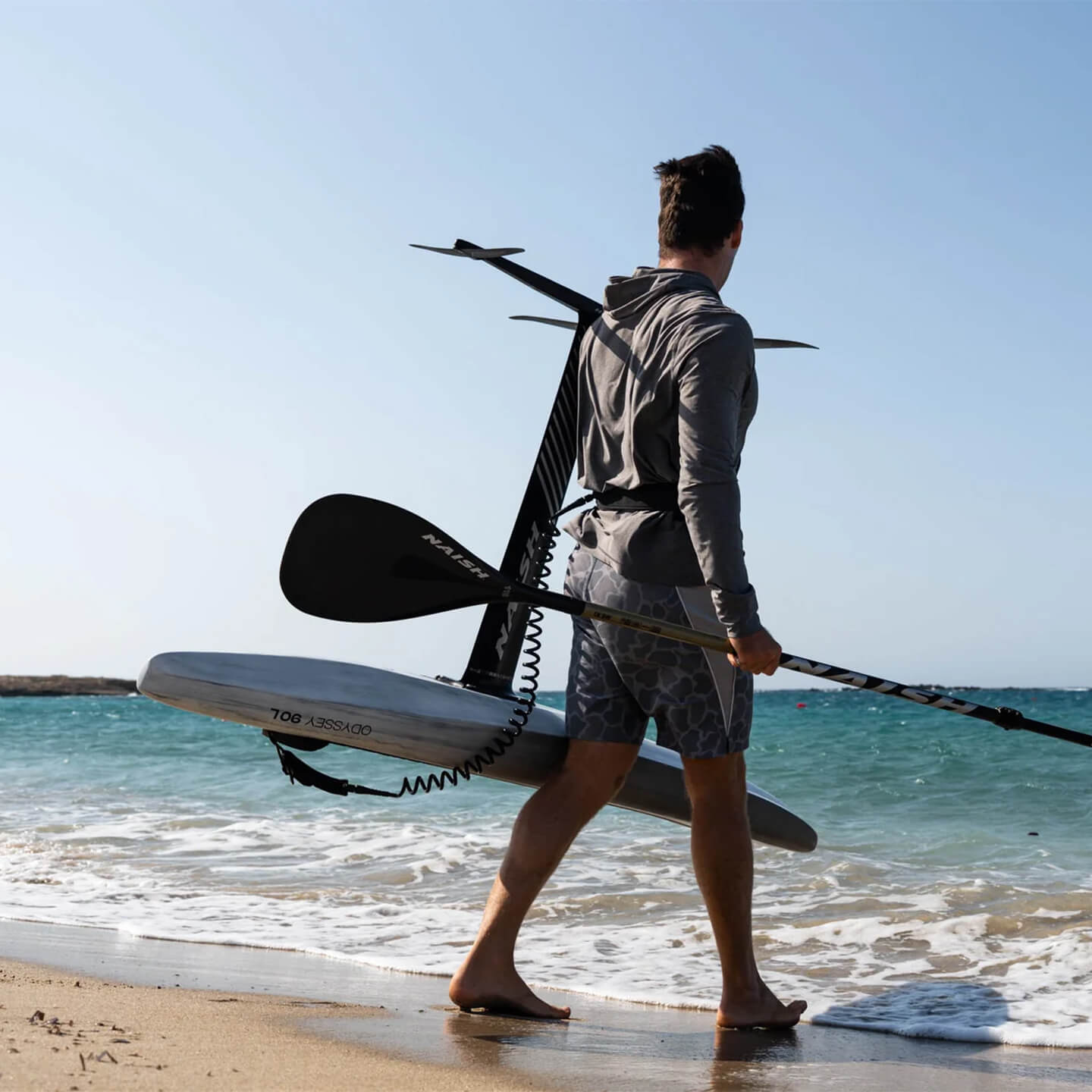 Naish Odyssey DW Foil Board 2026 carrying on beach