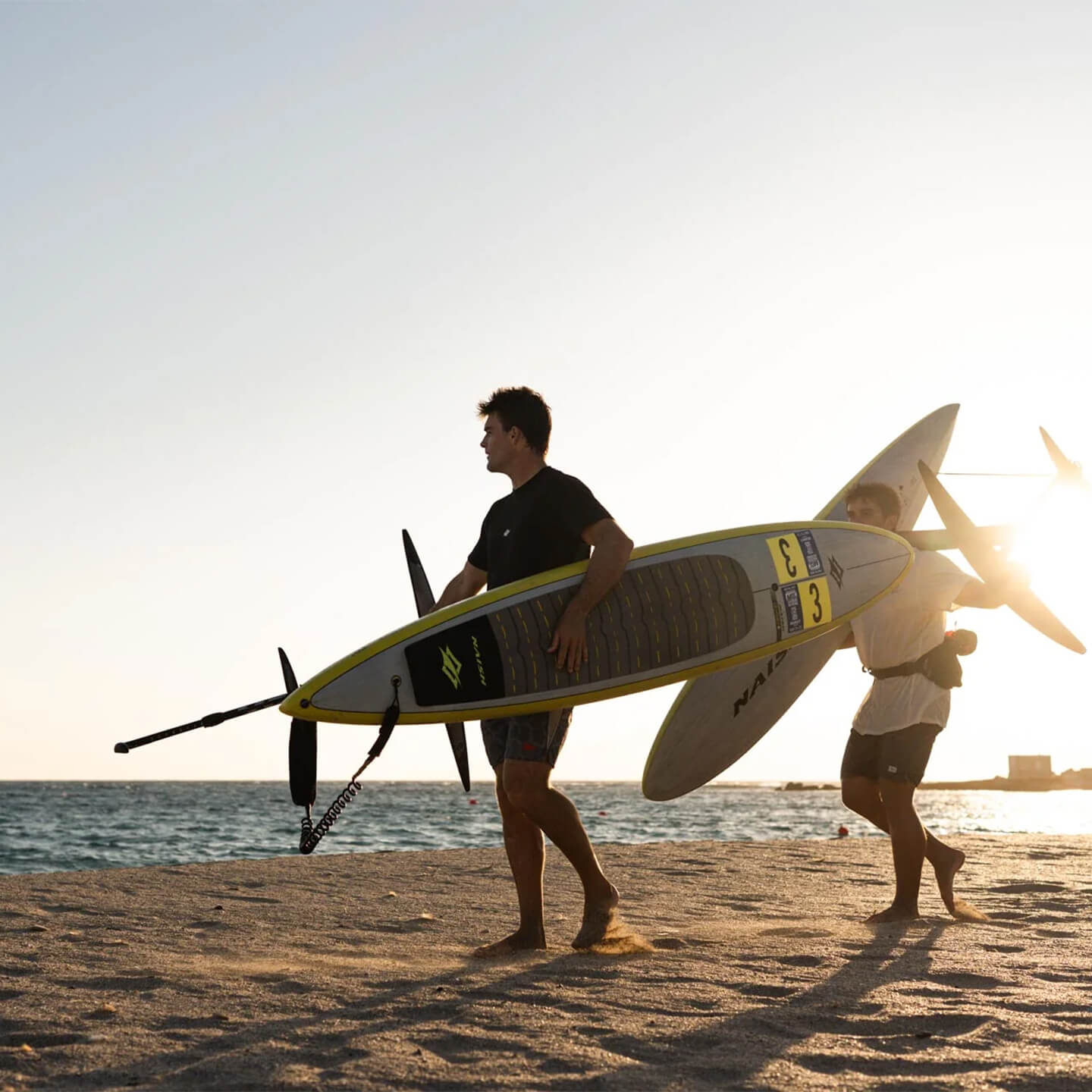 Naish Odyssey DW Nvision Foil Board 2026 carrying on beach